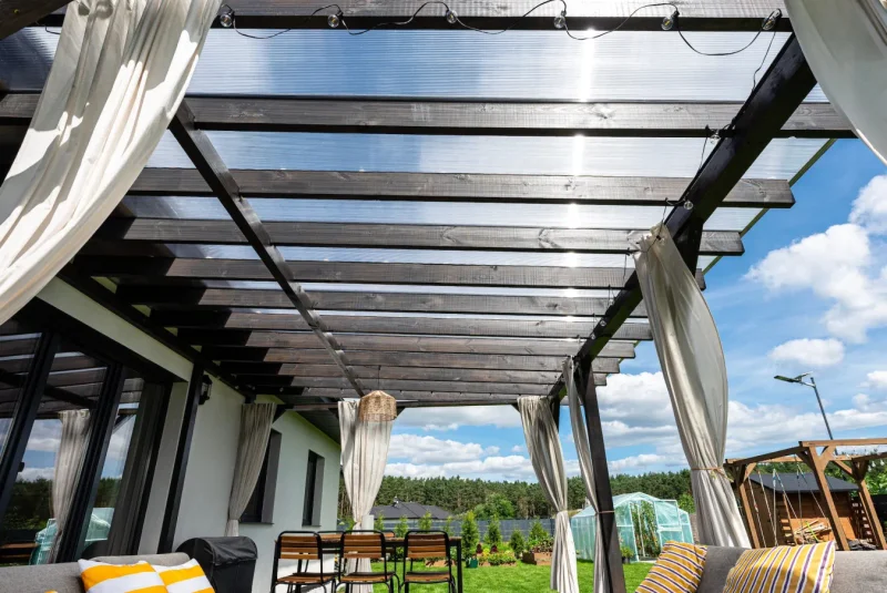 Dřevěná pergola na terase se zastřešením, závěsy a jídelním sezením